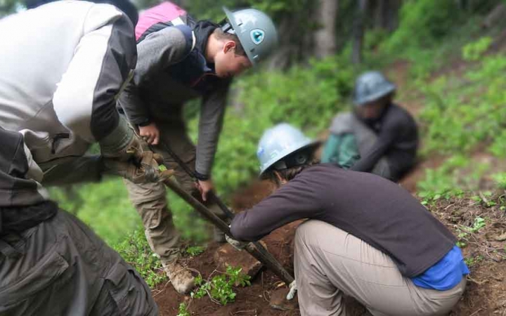 outward bound students use gardening tools during a service project